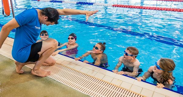 A swim instructor demonstrating front stroke to a group of young swimmers at Christchurch Recreation and Sport pool. 