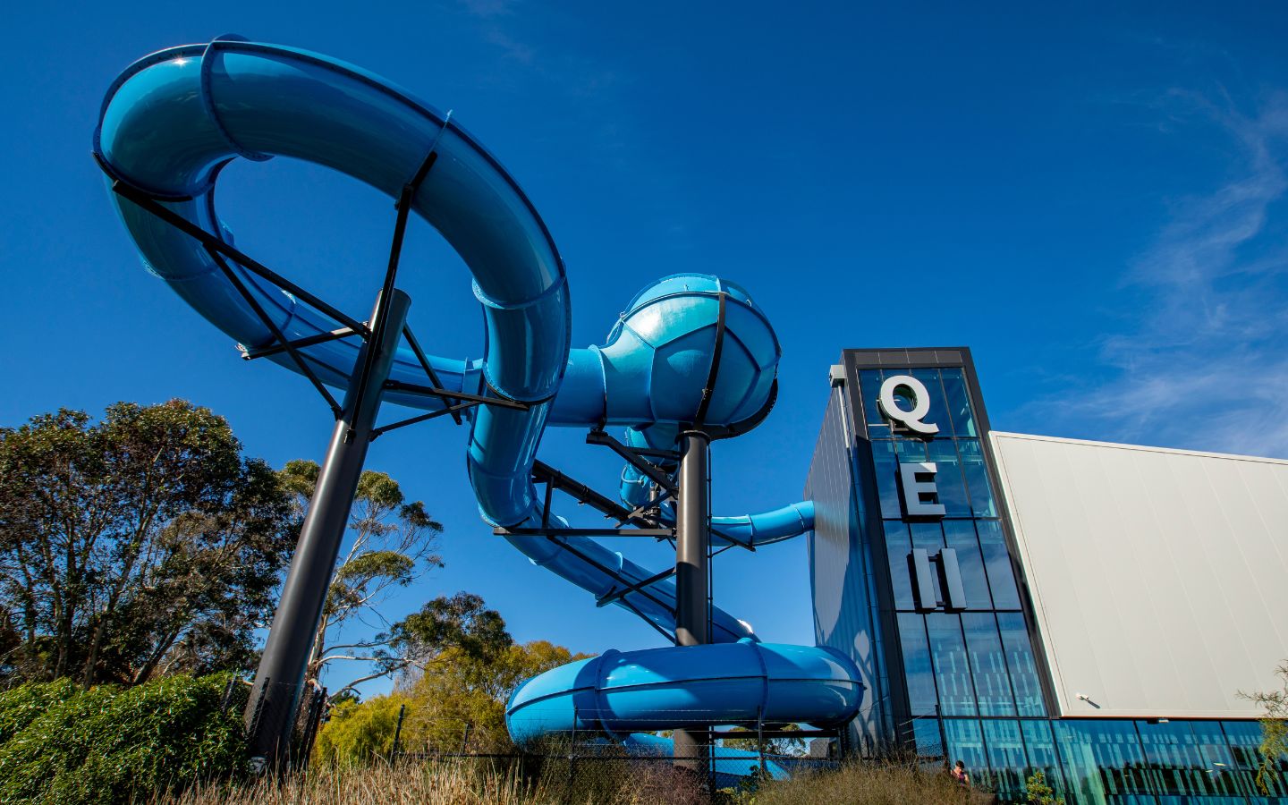 The large blue hydroslide on the outside of QEll Recreation and Sport Centre. 
