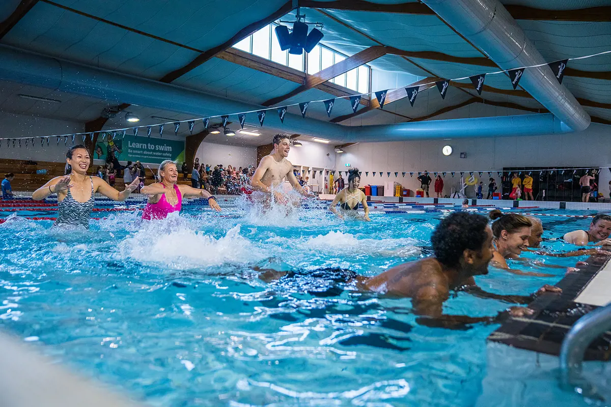 A group of eight adults participating in an Aqua Zumba class at Christchurch Recreation and Sport pool.