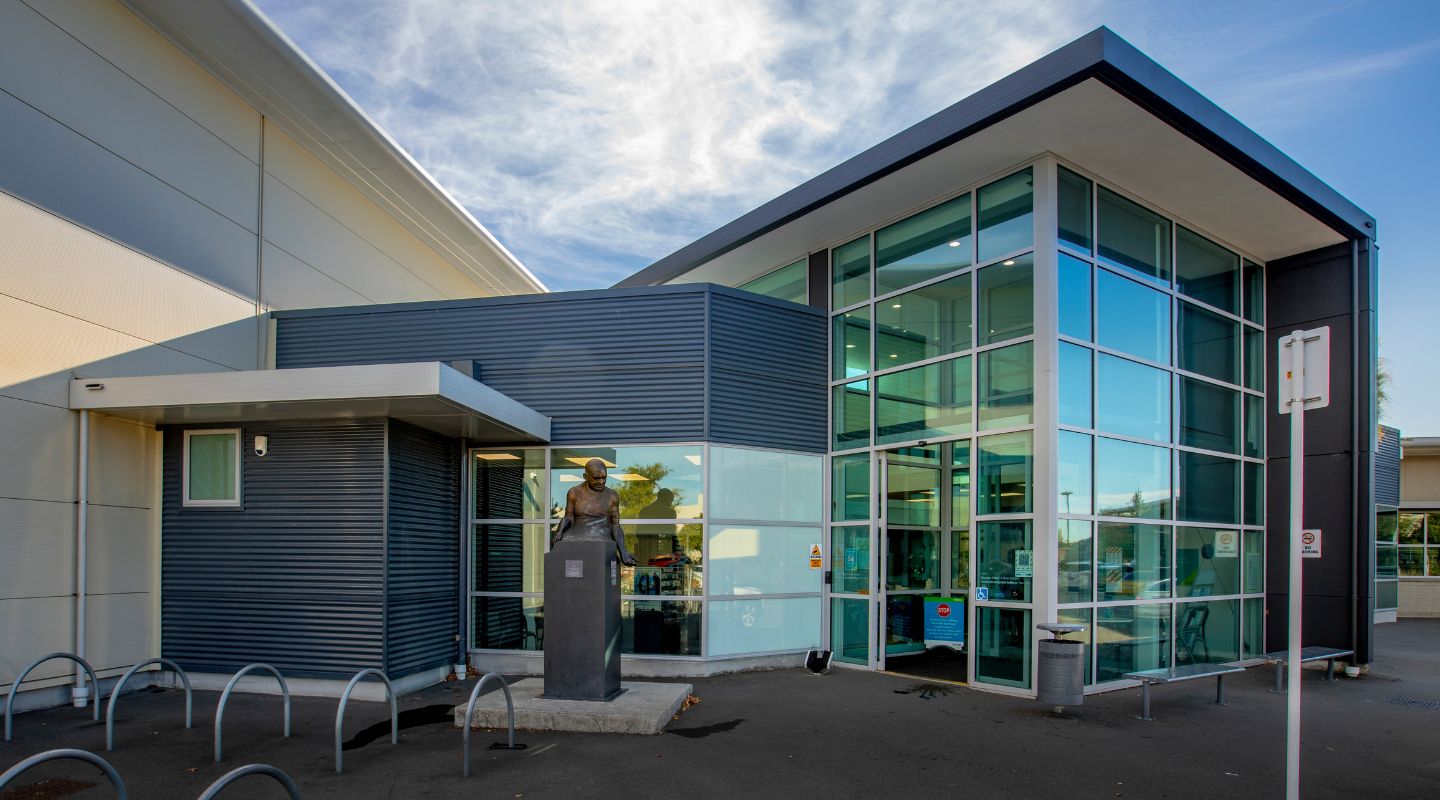 The outside of the Graham Condon building with a memorial statue of Mr. Graham Condon beside the exterior. 
