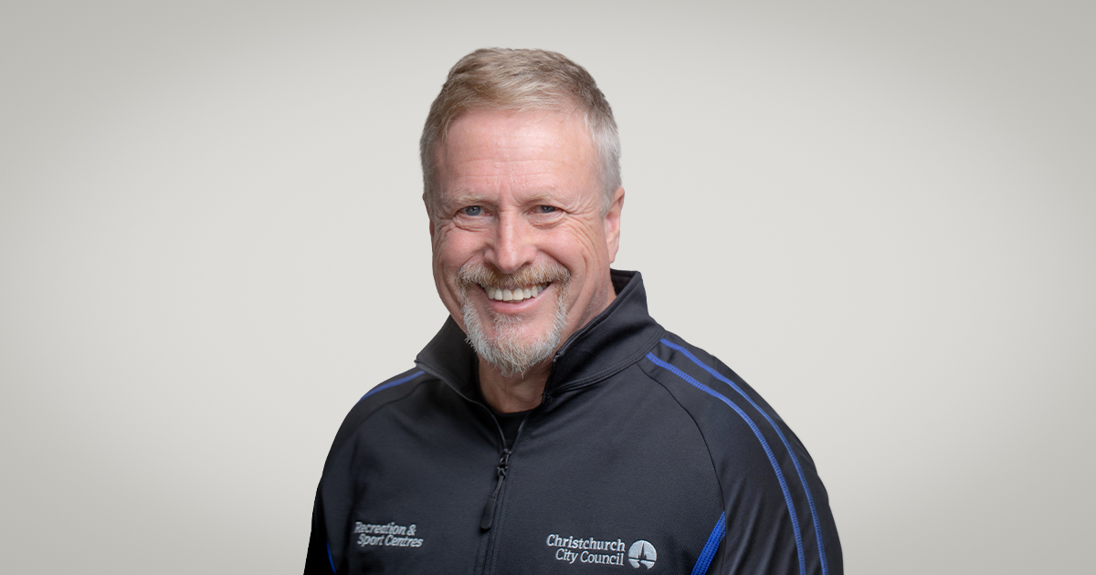 Smiling Personal Trainer, Stuart Dallow wearing and blue and black staff uniform. 